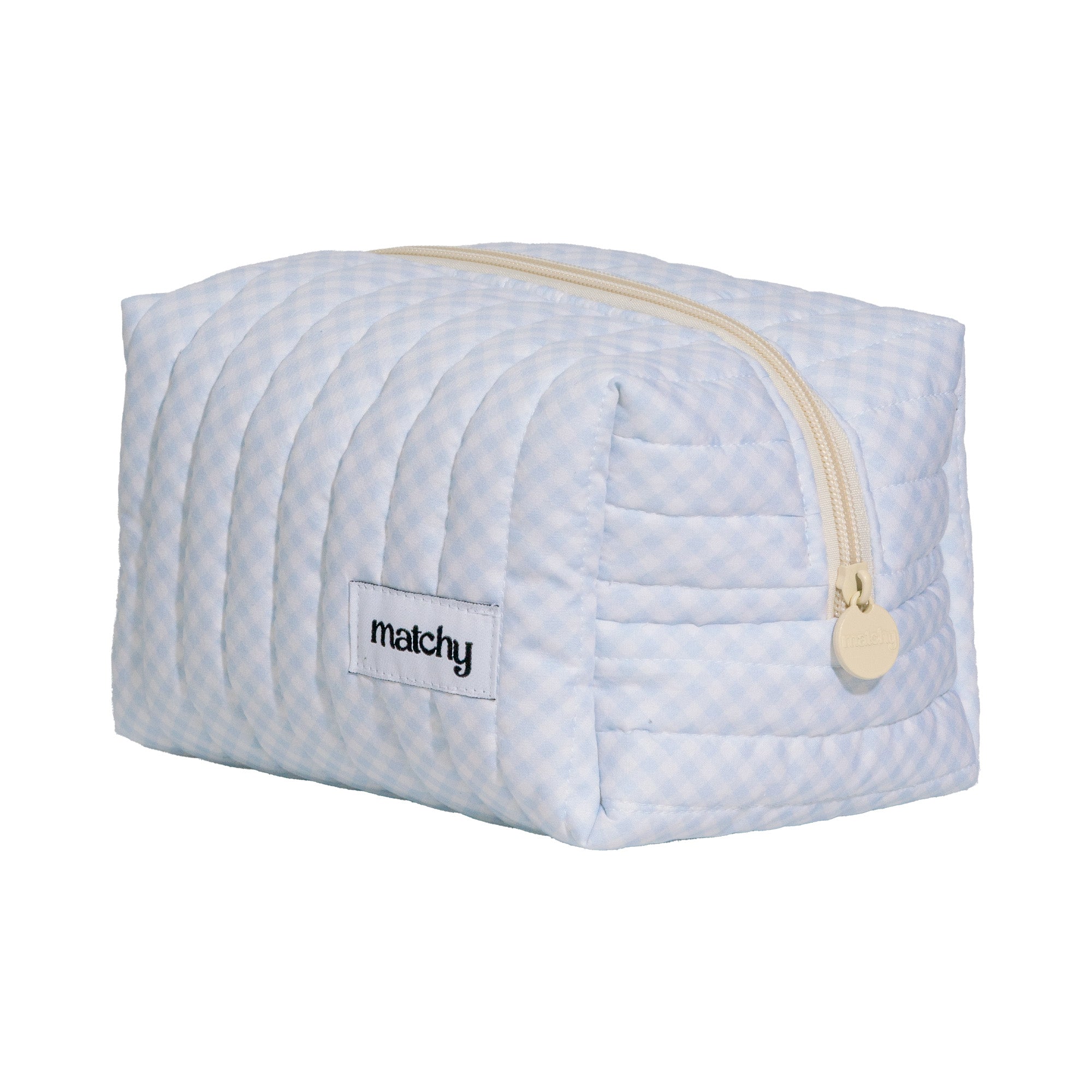 Angled view of a pale blue gingham quilted carry-all bag showing the cream zip and 'matchy' label. Matchy Blueberry Gingham Carry-All Bag.