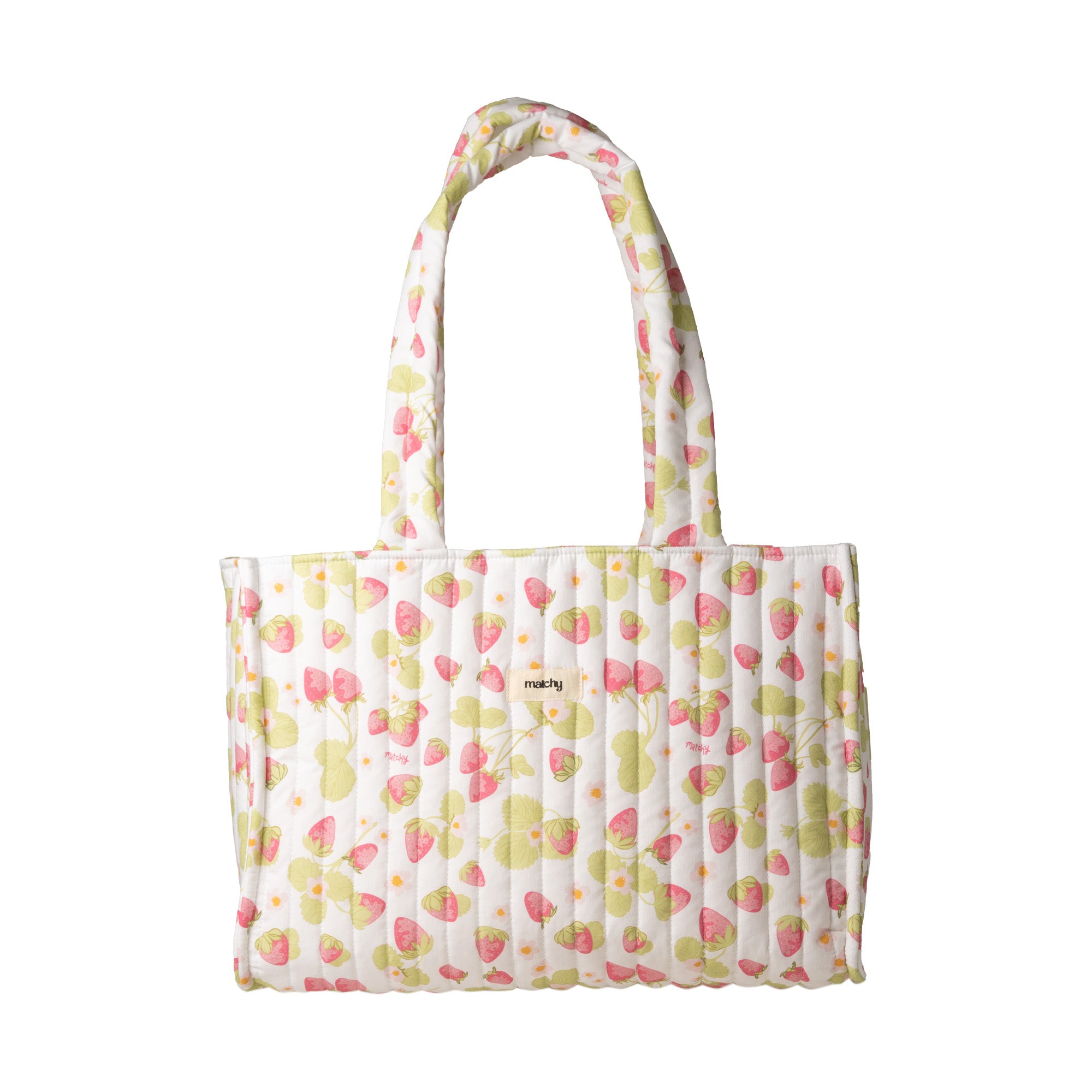 Quilted cream tote bag with a pink strawberry and green leaf print and two shoulder straps on a white background. Matchy Sofia Take Me With You Tote, a strawberry print quilted tote bag.
