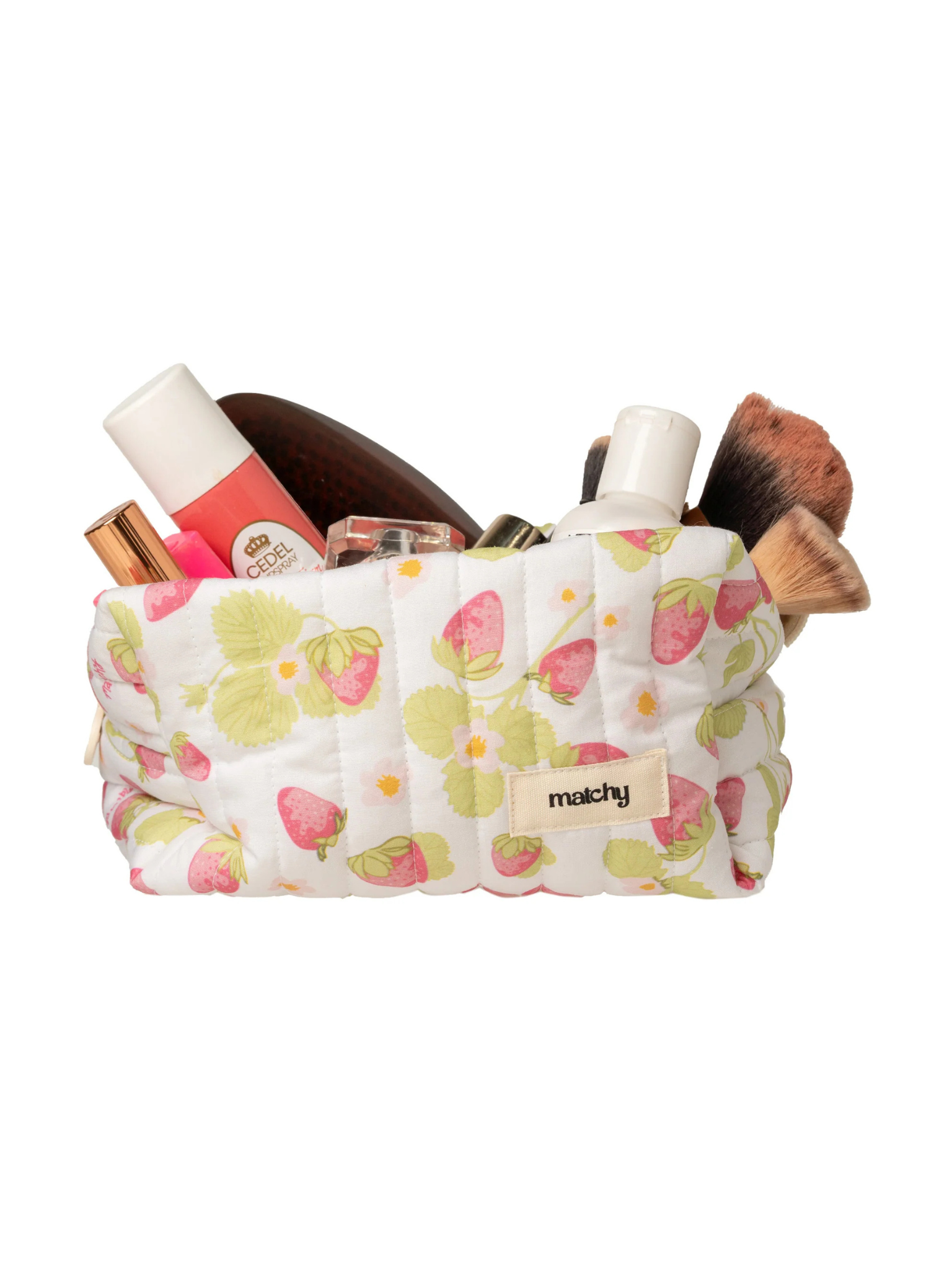 Strawberry print quilted carry-all bag overflowing with makeup brushes, lipsticks and skincare. Matchy Sofia Carry-All Bag, a quilted makeup and toiletry bag.